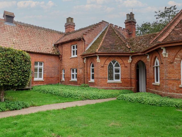 An outdoor view of a brick building with windows and a pathway at Duke Cottage in Woodbridge