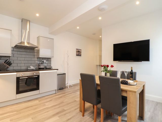 A kitchen with modern appliances and dining table at West Chambers in Camborne