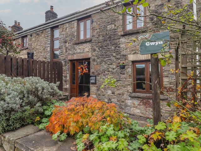 Stone building with plants and sign at Gwyn Studio in Aberdare