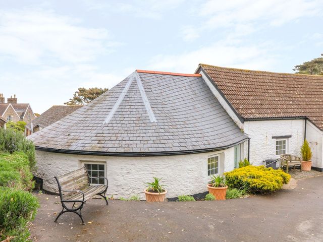 An outdoor area with a round house and seating at Round Barn Ilfracombe