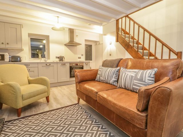 A living room with a sofa and armchair at Riverside Cottage in Conwy
