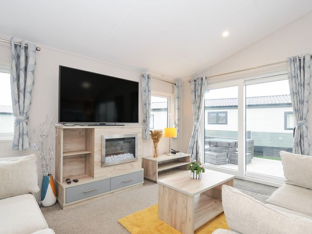 A living room with a television and fireplace at 2 Summerleaze in Bude