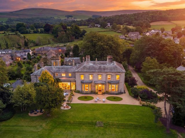 An outdoor view of a house with garden and surrounding landscape at The Country House Cumbria Castle Carrock