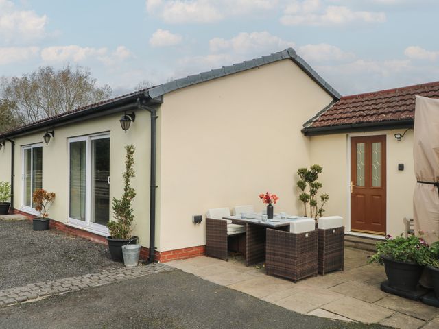 An outdoor seating area with a table and chairs at Pompian Lodge Leyland