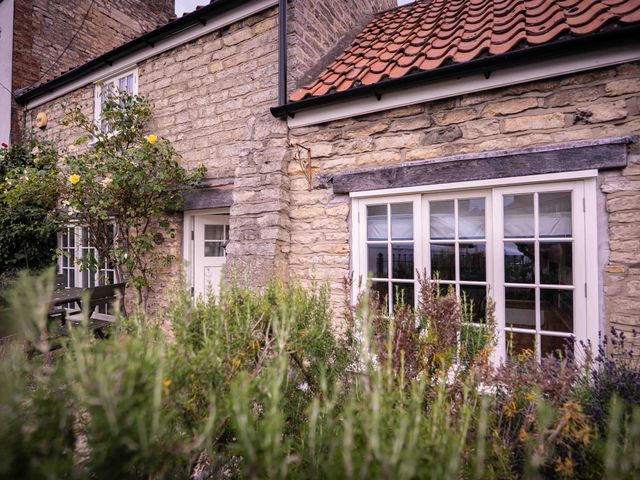 An exterior view of a cottage with a garden at Freya's Cottage in Metheringham