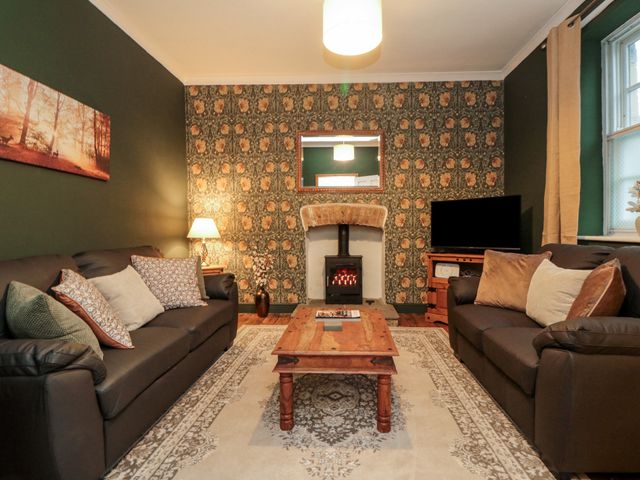 A living room with a fireplace and television at Daisy cottage in Pickering