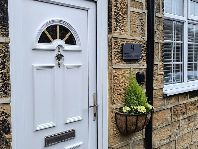 A front door with a flower pot at Cliffe Cottage in Brotton, North Yorkshire