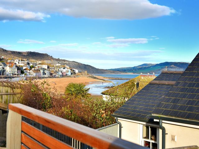 A view of the beach and sea with houses in the background at proposed 3 bed apartment in Lyme Regis