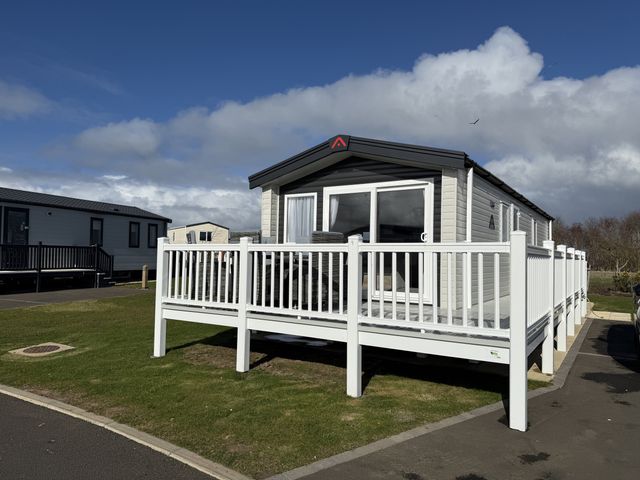A cabin with a deck and windows at 30 Wells Close Berwick-upon-Tweed