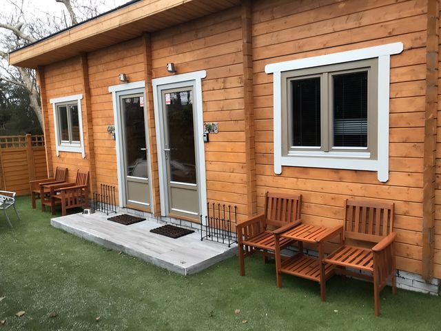 An outdoor area with a wooden house and seating at Duncairin cabins