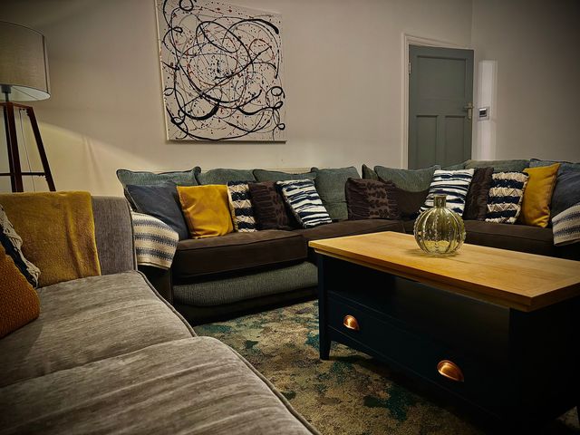 A living room with a sofa and coffee table at Horncliffe Hot Tub House