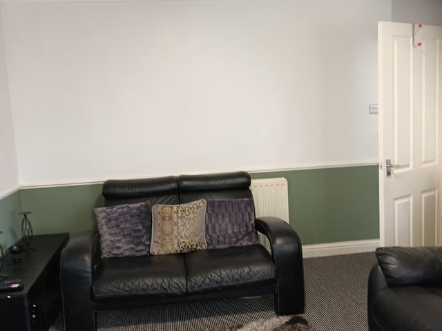 A living room with a sofa and cushions at 11 Kings Court