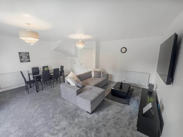 A living room with a sofa and dining table at the property