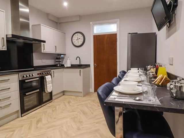 A kitchen featuring an oven, sink, and dining area with table at a property