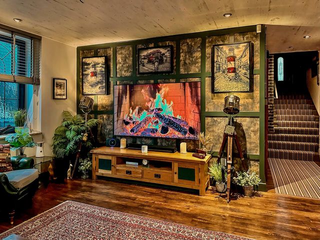 A living room with a fireplace and television at a property