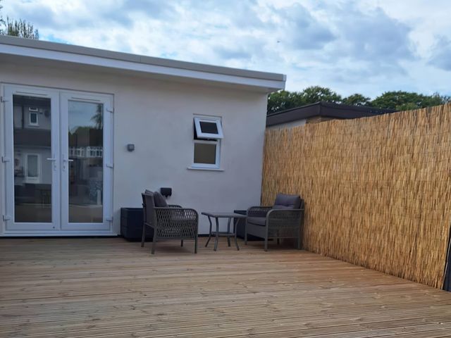 An outdoor patio with seating and a bamboo screen at The Old Barn in Manchester