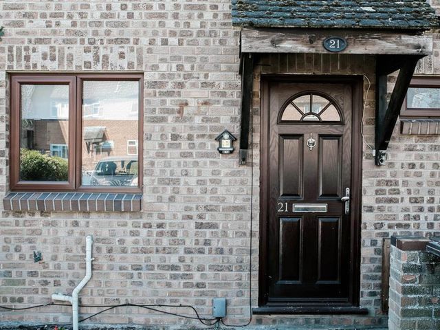 A front door and window on a brick wall at 21