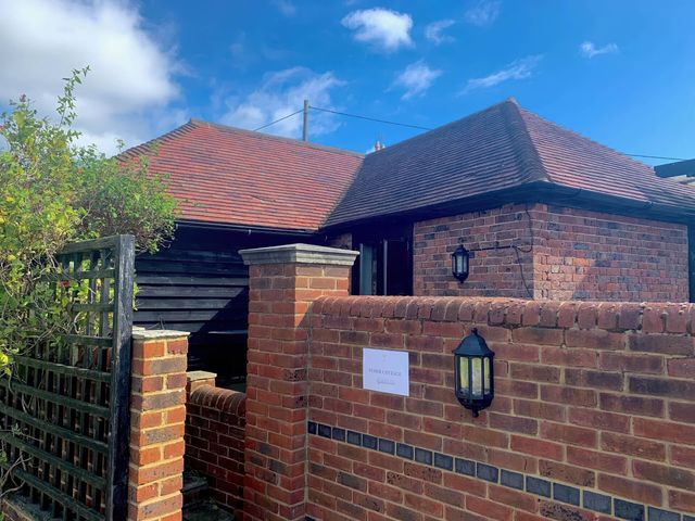 An outdoor view of a cottage entrance with brick walls at The Old Cottage in an unspecified location