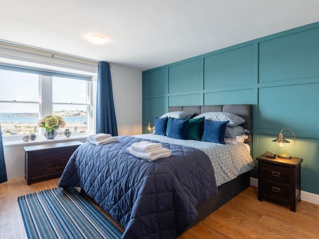 A bedroom with a large bed and ocean view at the coastal property in unspecified location