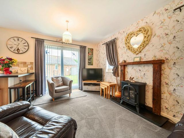 A living room with a television and a sofa at Ivy Corner in Bridlington