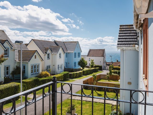 A view of houses and ocean from a balcony at Acorn Court