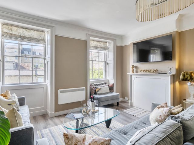 A living room with a television and seating arrangement at Stay Robun in Bath