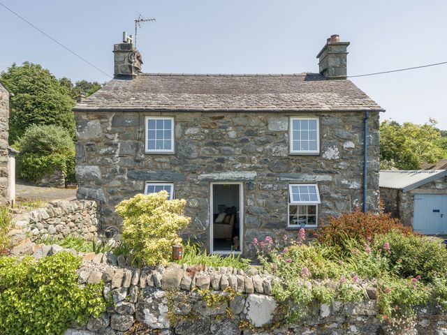 A house with stone exterior and garden at Bwthyn Nain in Harlech