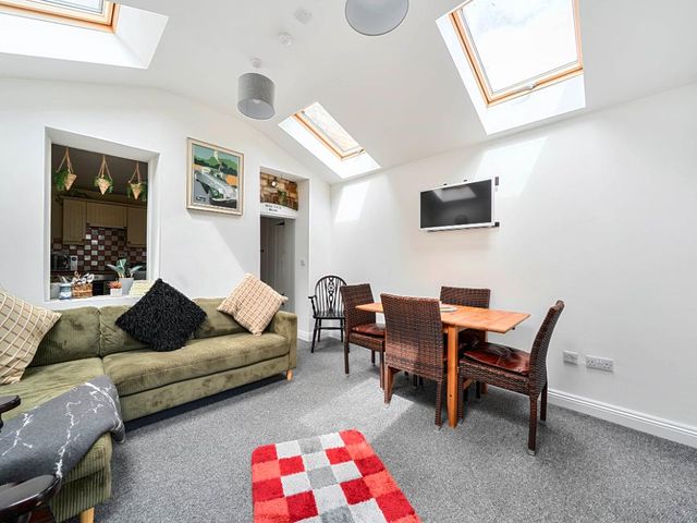 A living room with a sofa and dining area at Charming Lincoln Cottage in Lincoln