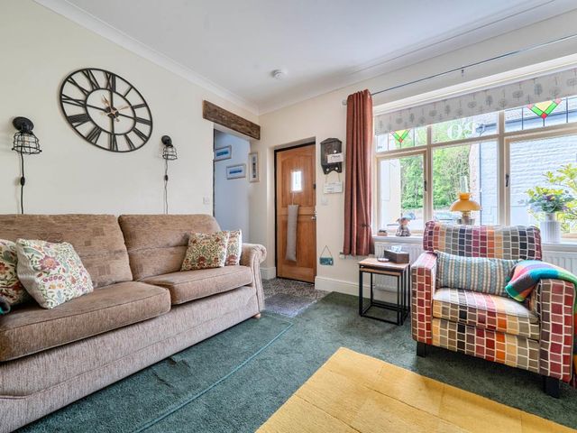 A living room with a sofa and armchair at 20 Main Street in Heysham