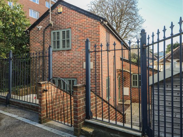 A brick building with windows and a gate at Tiffanys Coach House Bournemouth