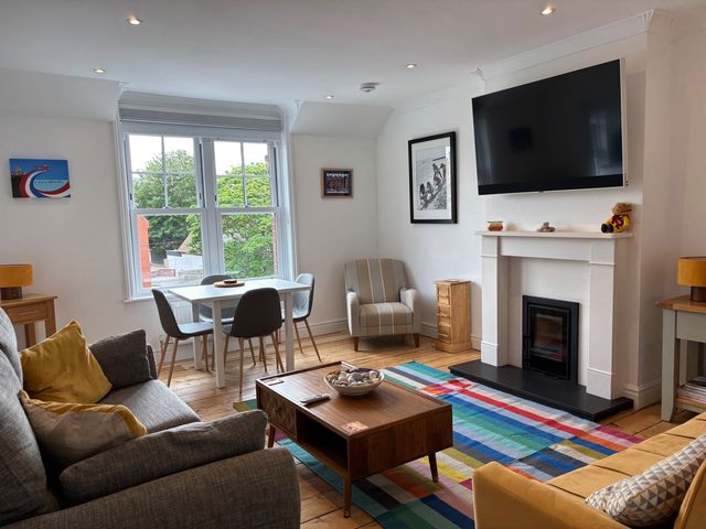 A living room with a television and seating area at Edal Court in Sheringham