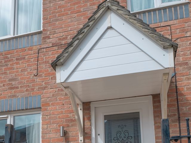 A roof over a doorway with a brick wall at Rochester Road Corby