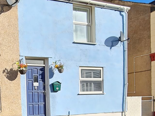 An exterior view of a house with a blue door and window at Blue Haven in Penmaenmawr