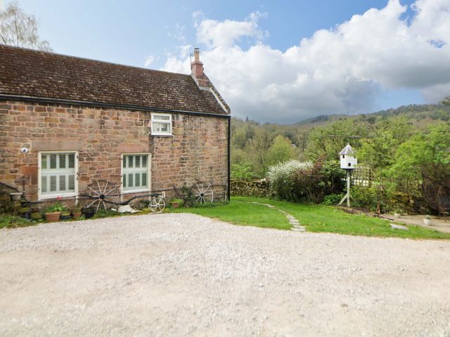 A cottage with a garden and birdhouse at Meadow View Cottage Whatstandwell near Crich