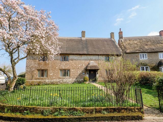 A cottage with a thatched roof and garden at Manor Cottage in Kingstone near Ilminster
