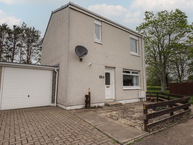 A house with a driveway and garage at Clans Crescent in Nairn