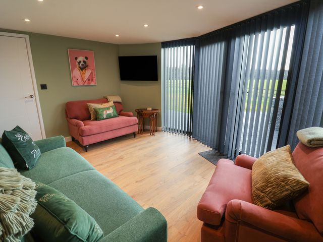 A living room with a television and seating at Unit 1 in Ipswich