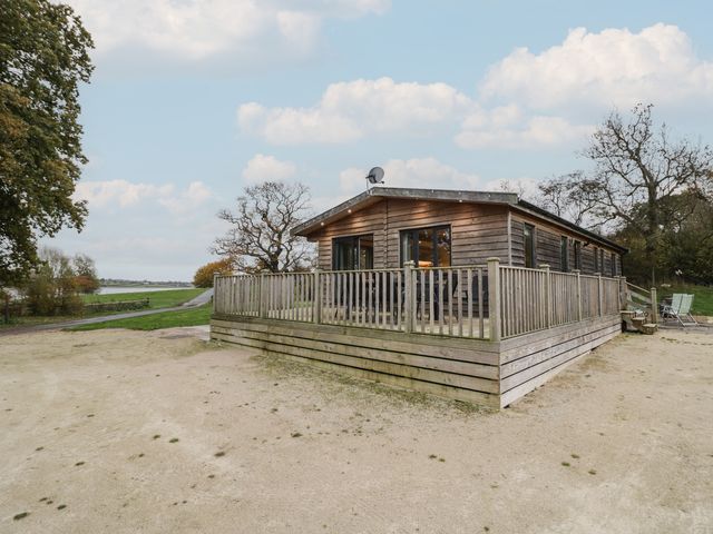 A log cabin with a wooden deck and pathway at Oak Lodge in Admaston near Abbots Bromley