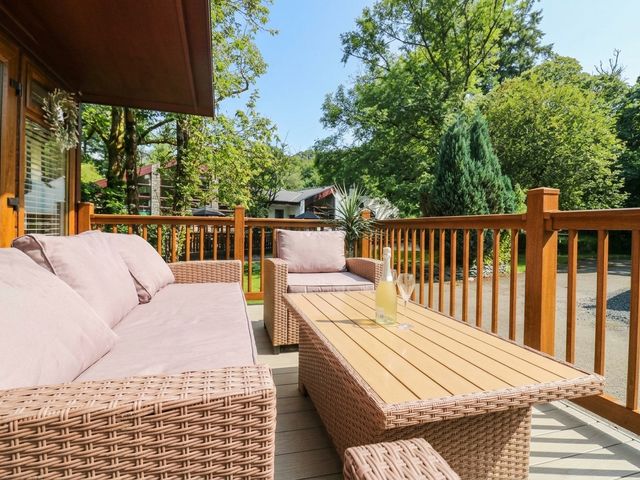 A patio with a sofa and coffee table at Terabitha Lodge in Troutbeck