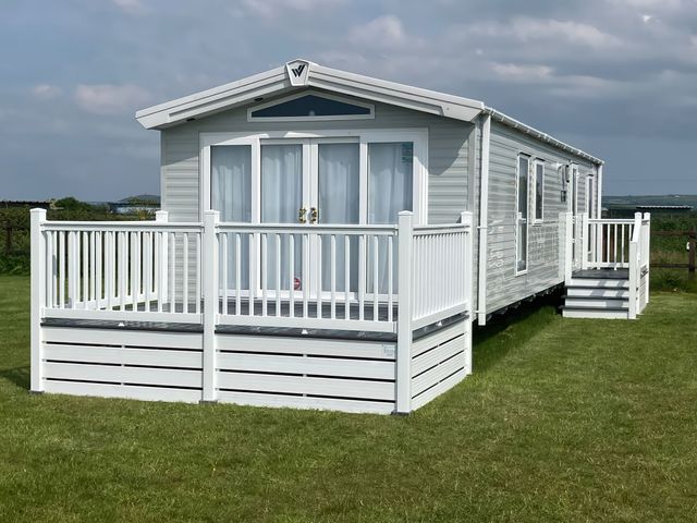 A mobile home with a deck and steps at Lamorna in Hayle