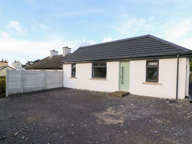 A house with a green door and windows in an outdoor area at Duck Cottage