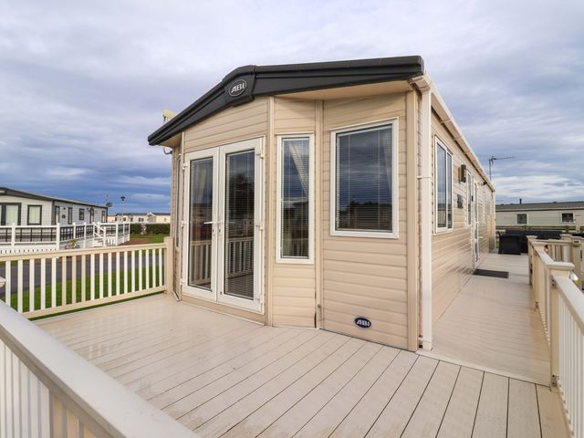 A cabin with a deck and windows at The Drift in High Skirlington near Skipsea