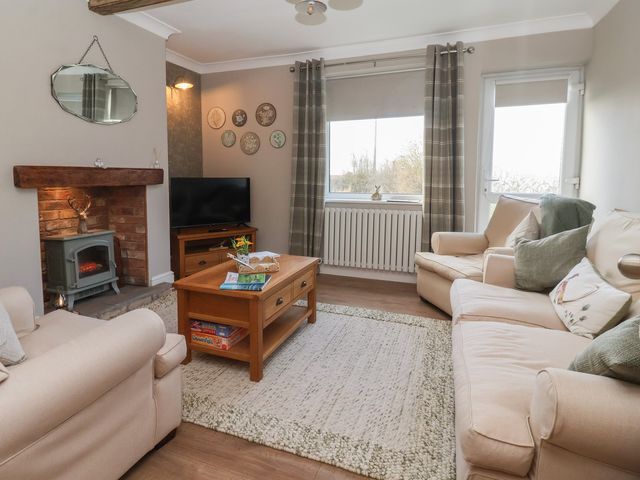 A living room with a sofa and a coffee table at Daffodil Cottage in York