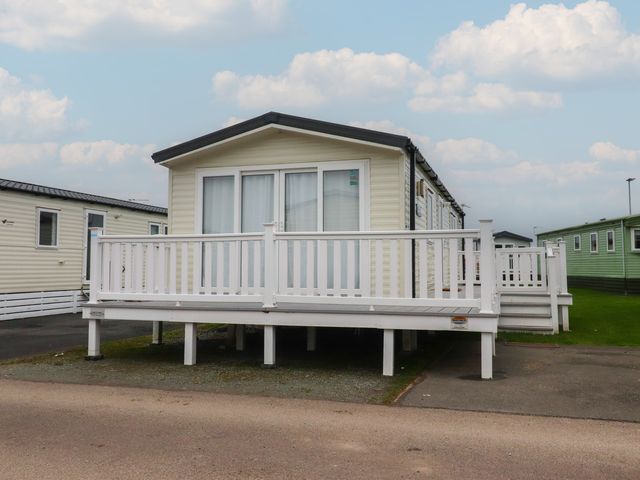 A mobile home with a deck at Poppy Lodge in Heysham