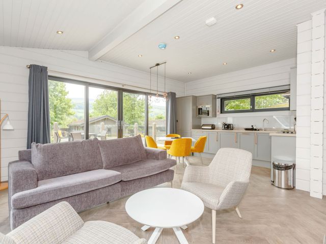 A living room with a sofa, chairs, and a kitchen area at Leyburn (Pet) Leyburn