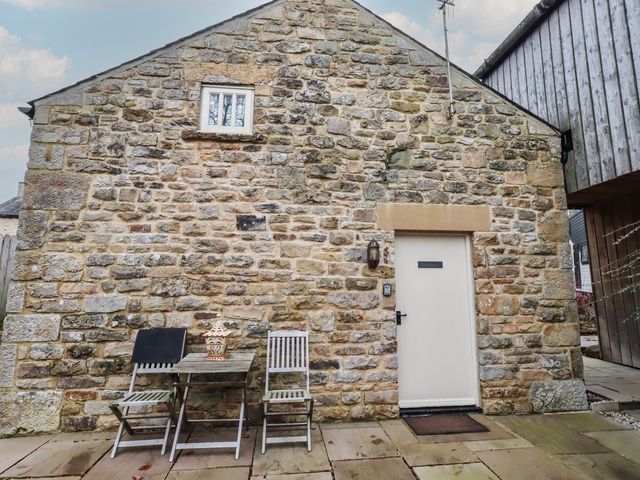 An outdoor area with a stone wall, table and chairs at The Medieval Romantic in 