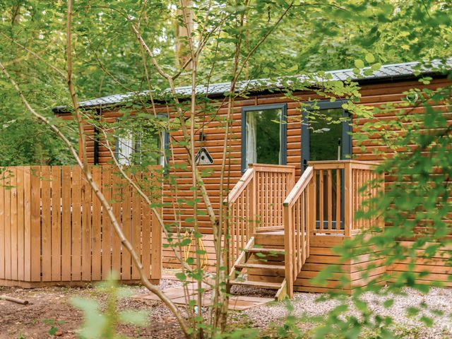 A cabin with a wooden fence and stairs at Alford Spa in Louth