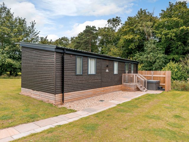 A single-story cabin with a deck and hot tub at The Kinder Spa in Louth