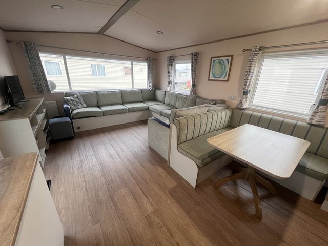 A living room with a sofa and dining table at New Caravan in 