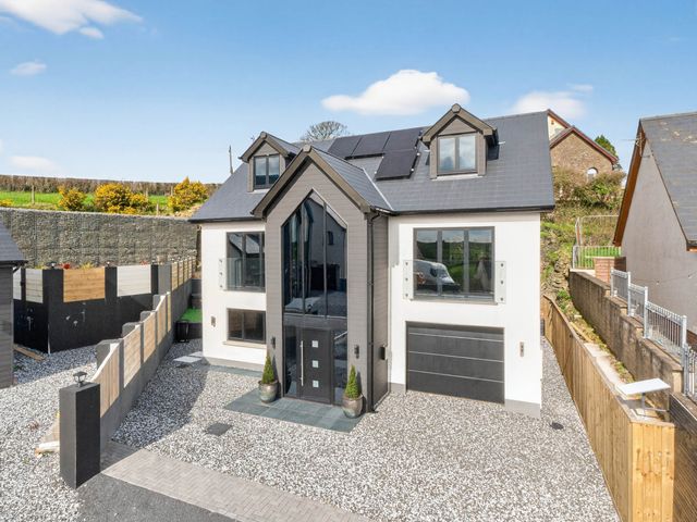 A house with solar panels and a gravel driveway at Heddfan in Carmarthen